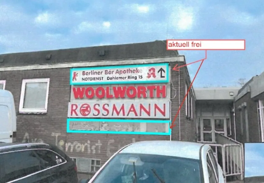 Fassade einer Einkaufspassage mit Sammelwerbeanlage, das freie Feld rot markiert